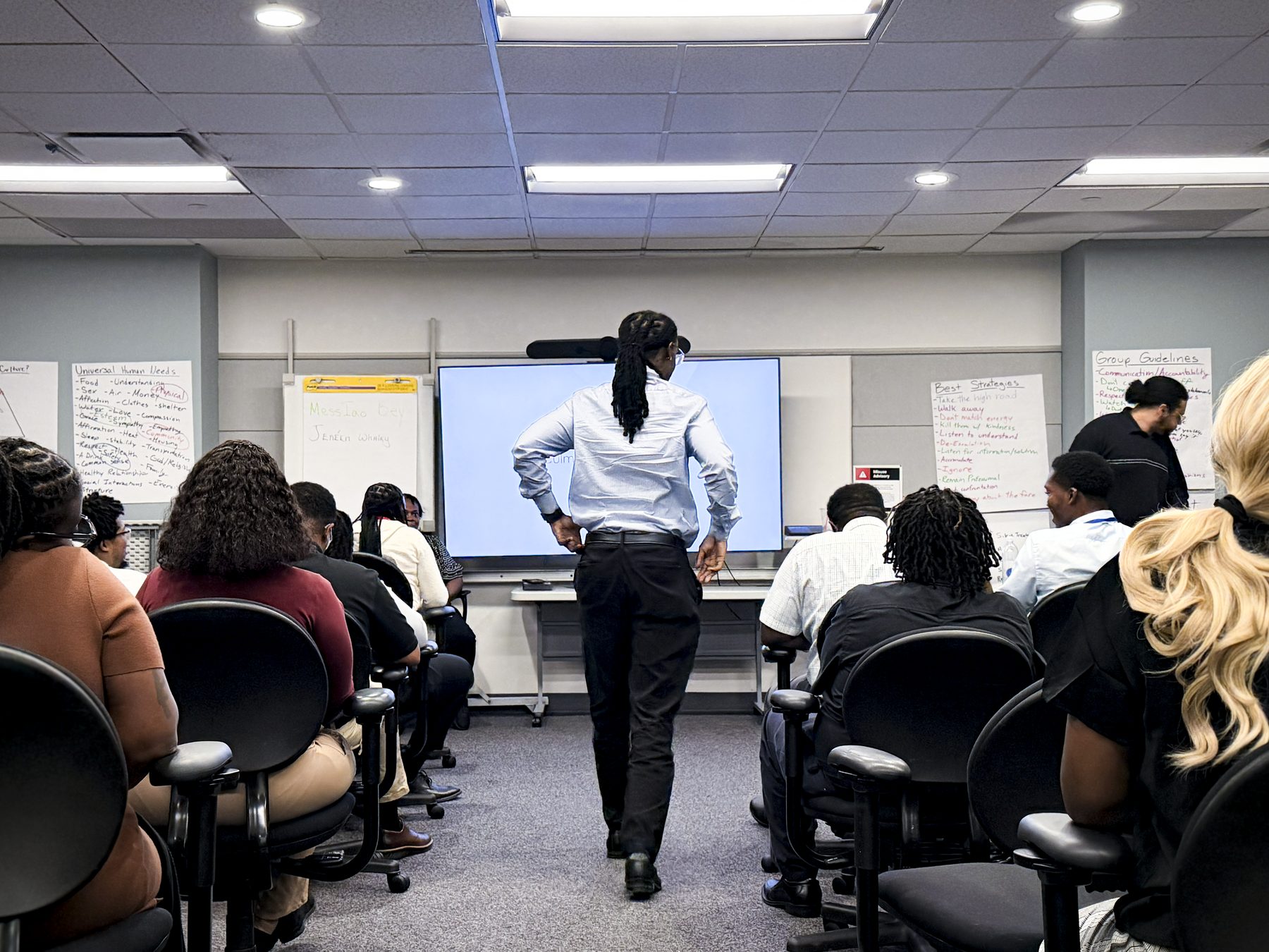 Red Kite Project participant standing during a workplace resilience training session with other participants seated in a classroom.